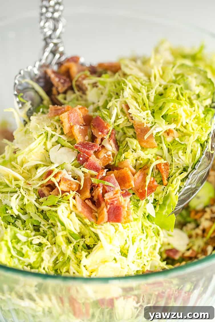 Tossing brussels sprouts salad with bacon, pecans and Parmesan cheese.
