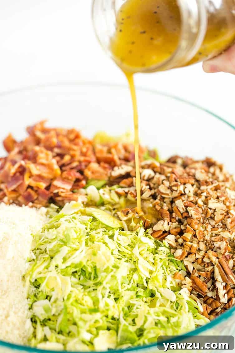 Pouring dressing over a shaved Brussels sprouts salad.