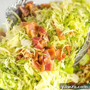 Tossing brussels sprouts salad with bacon, pecans and Parmesan cheese.