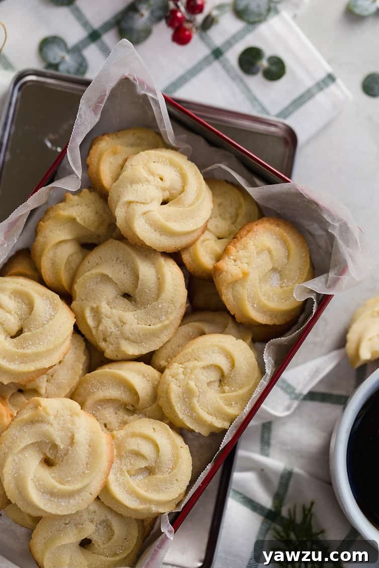 A batch of Danish butter cookies in a parchment-lined tin.