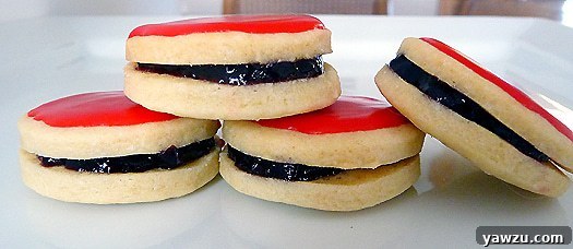 A delightful platter of four Empire cookies, perfectly iced and ready for festive indulgence.