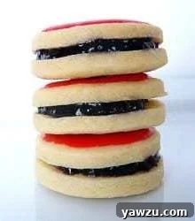 A beautiful stack of three festive Empire cookies, ready to be enjoyed.