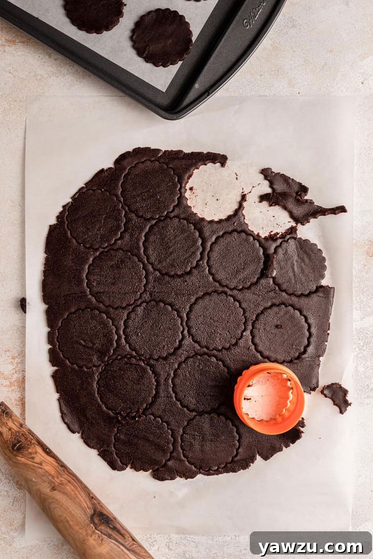 Cutting out circles from chocolate cookie dough.