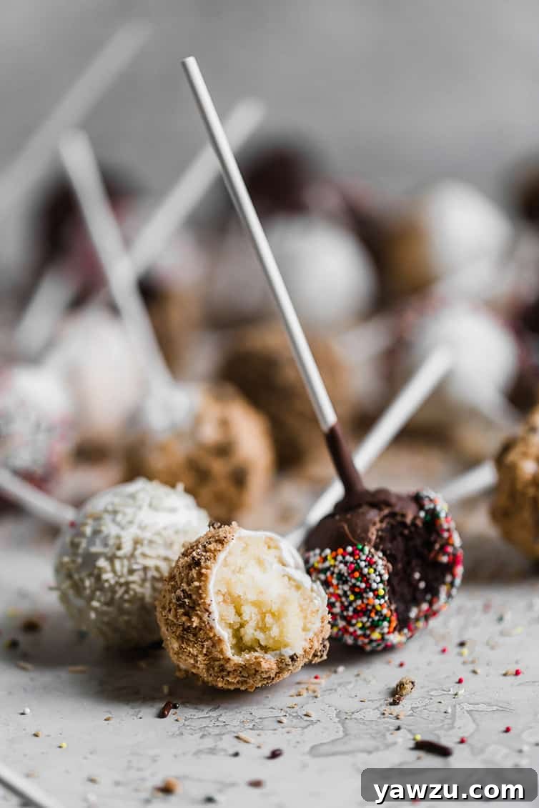 Vanilla and chocolate cake pops with bites taken out, showcasing the moist interior and perfect coating.
