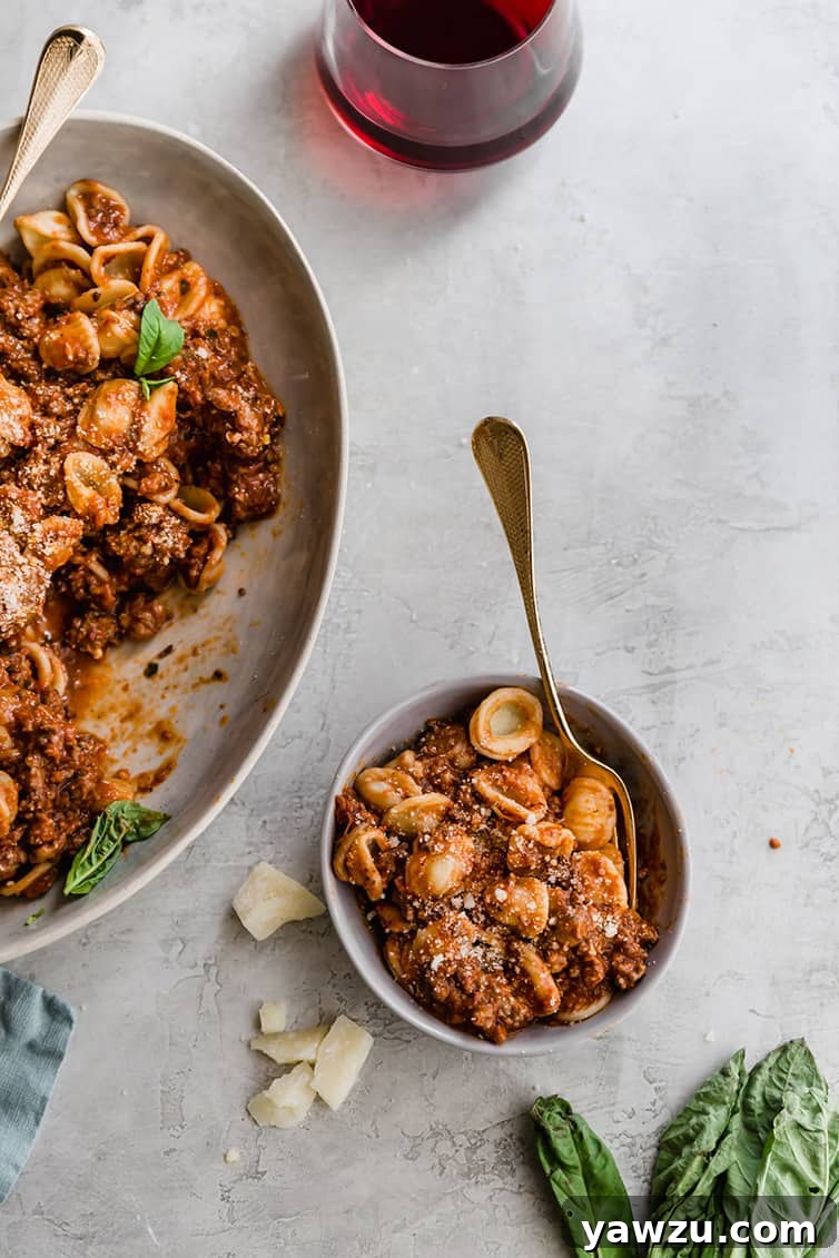 A small serving dish filled with pasta and rich bolognese sauce, ready to be enjoyed.