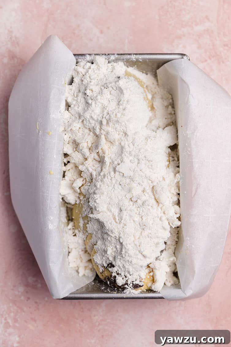 A loaf of babka topped with a generous layer of streusel, awaiting its final rise and journey into the oven.