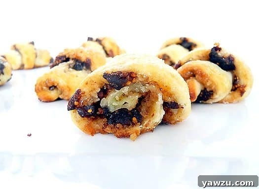 Close-up of baked rugelach cookies, revealing the beautiful flaky layers and generous filling inside each crescent.