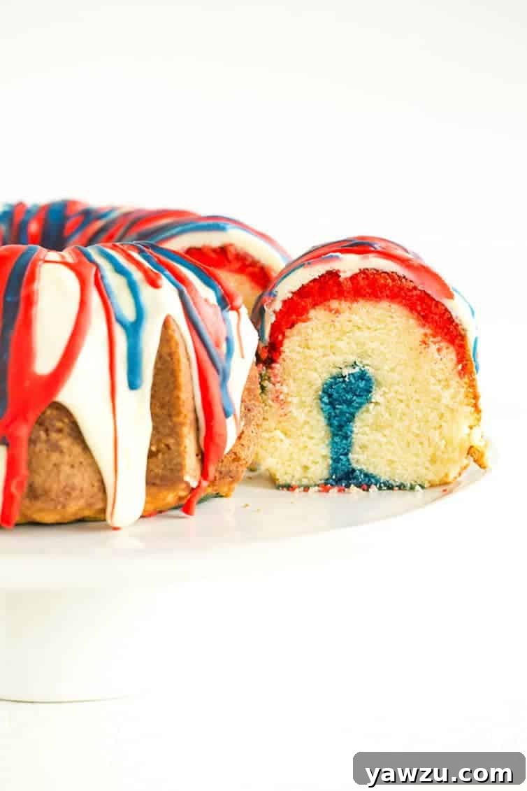This homemade Firecracker Cake features vibrant layers of red, white, and blue batter, creating a festive display.