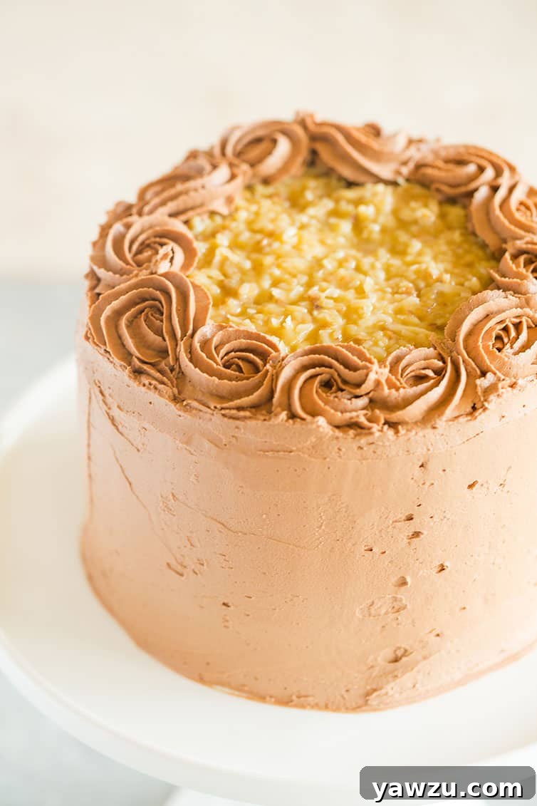 A beautifully layered German chocolate cake on a pristine white pedestal cake plate, ready to be served.