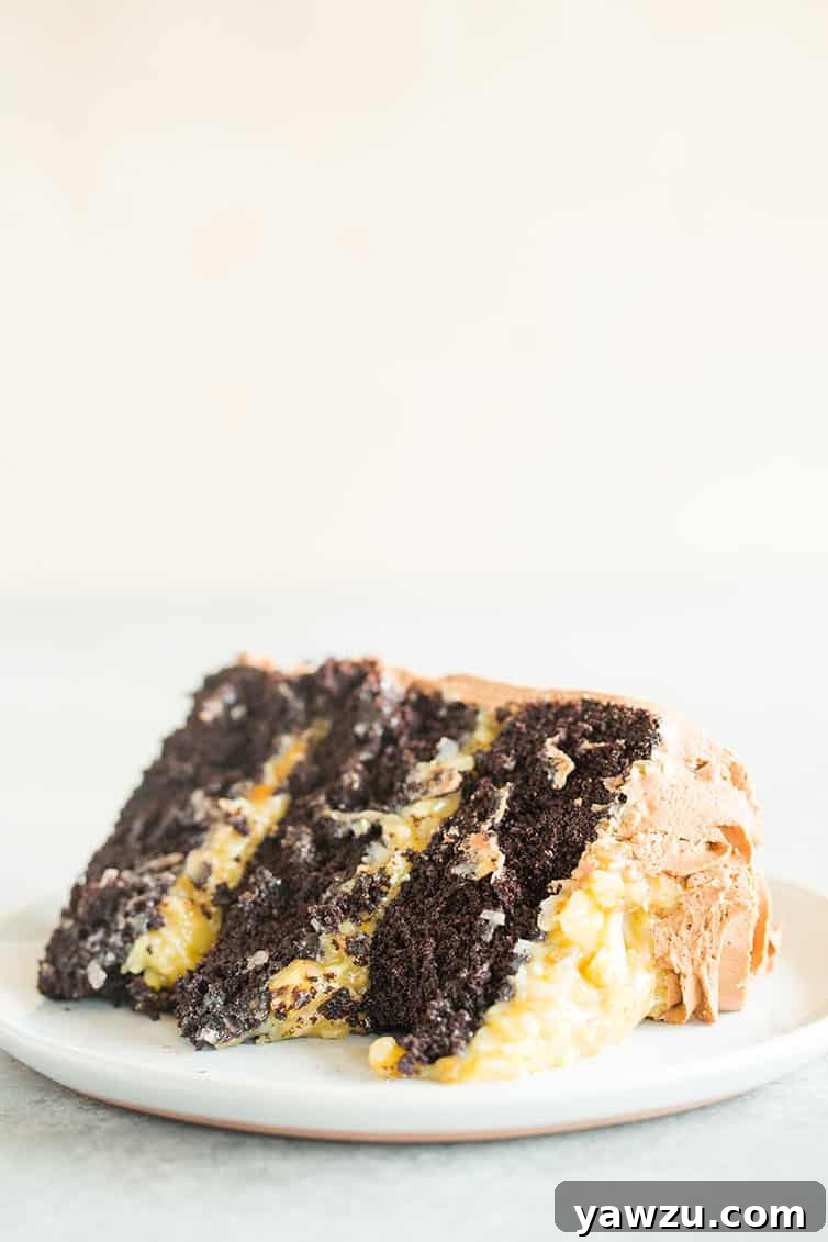 An inviting slice of German chocolate cake, perfectly positioned on its side on a white plate, showcasing its layers.