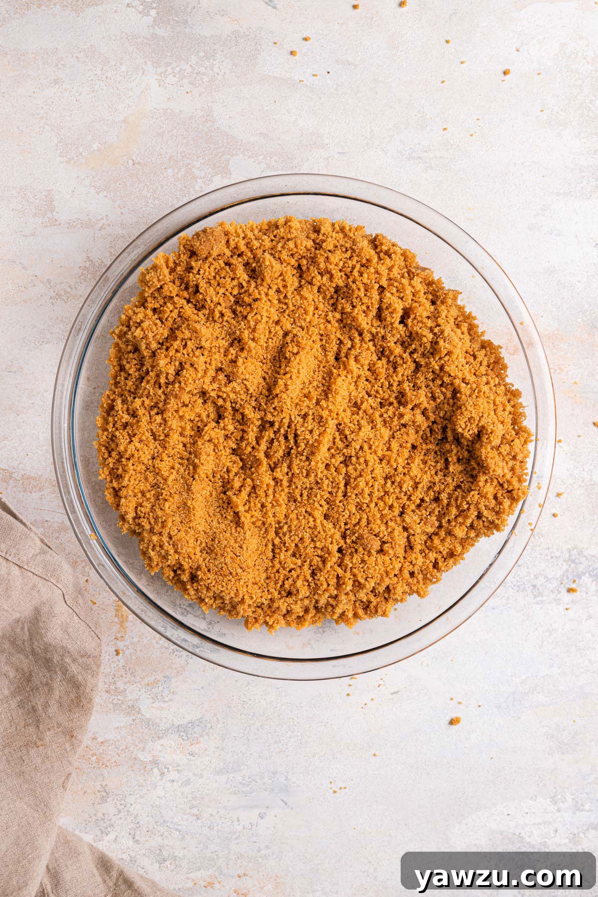 Graham cracker crust poured into a glass pie plate.