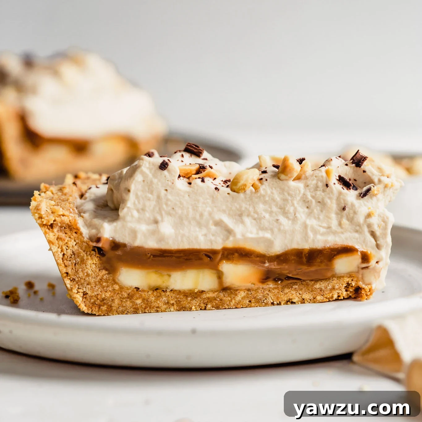 Slice of banoffee pie on a white plate.