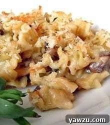 Mushroom and herb macaroni and cheese on a white plate, ready to serve.