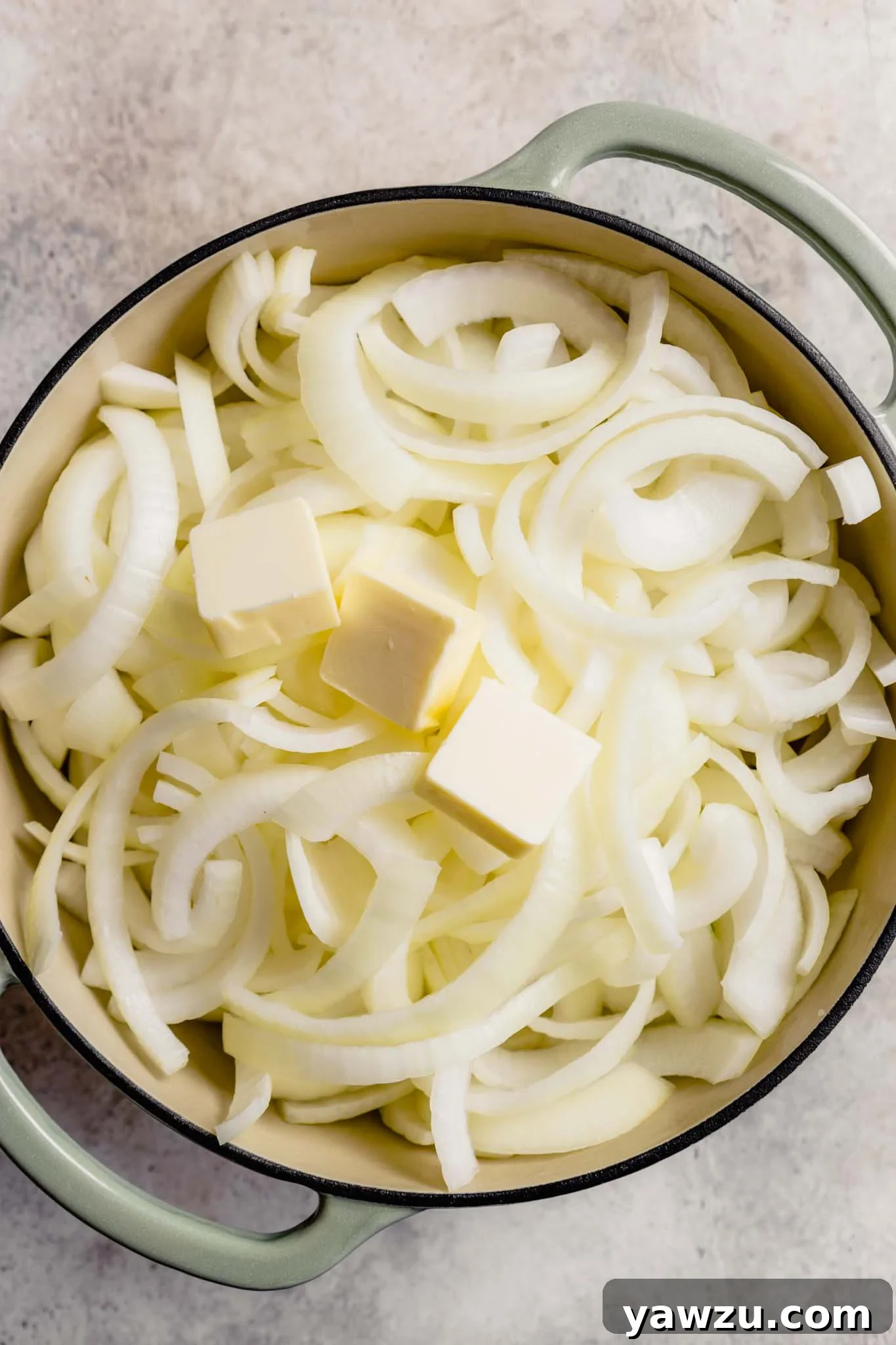 Sliced onions and butter in a pot.