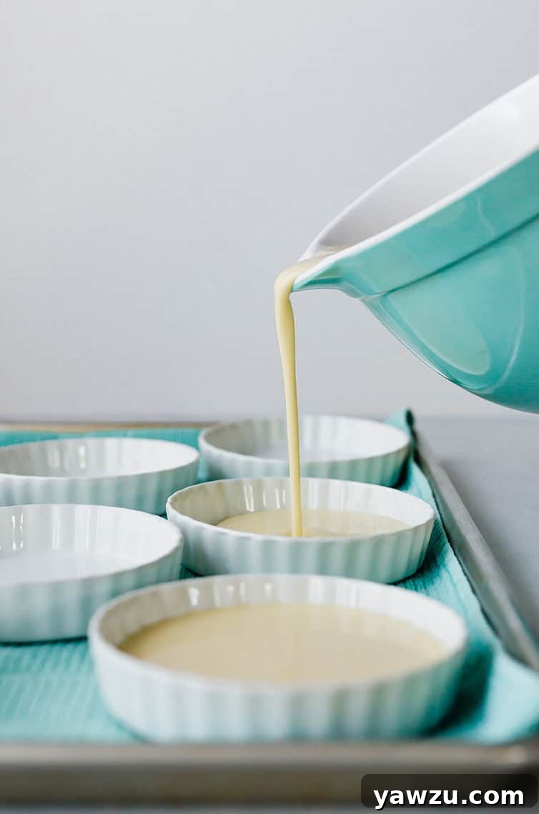 Pouring the vanilla custard mixture into ramekin bowls for creme brulee.