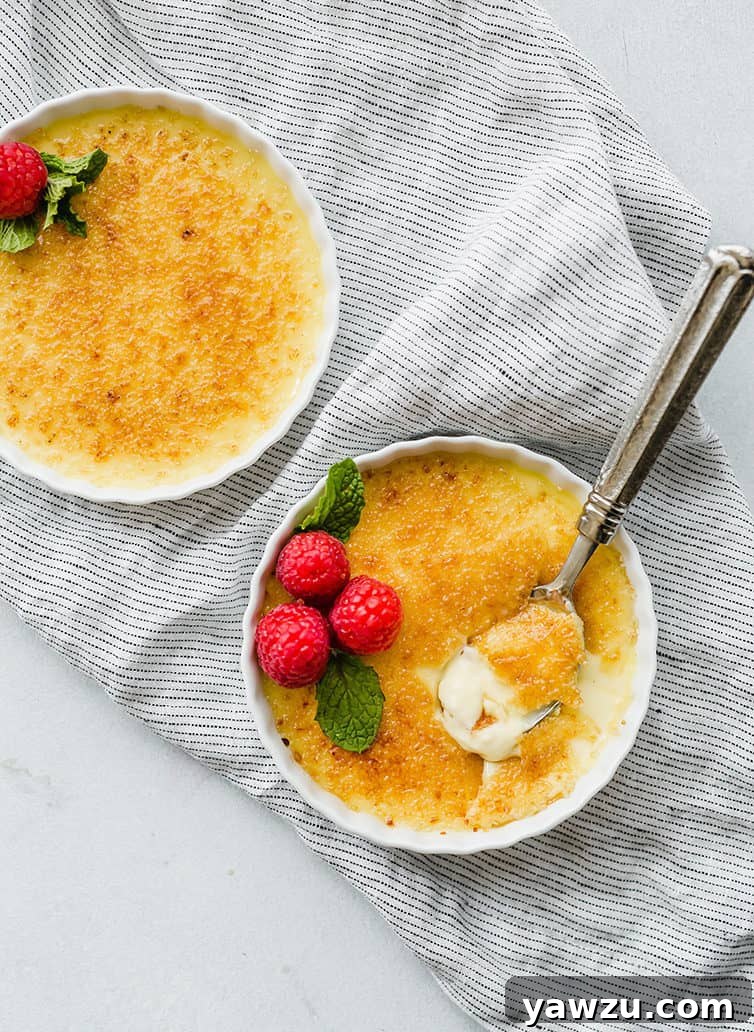 Two ramekins of creme brulee with a perfect golden brown sugar crust.