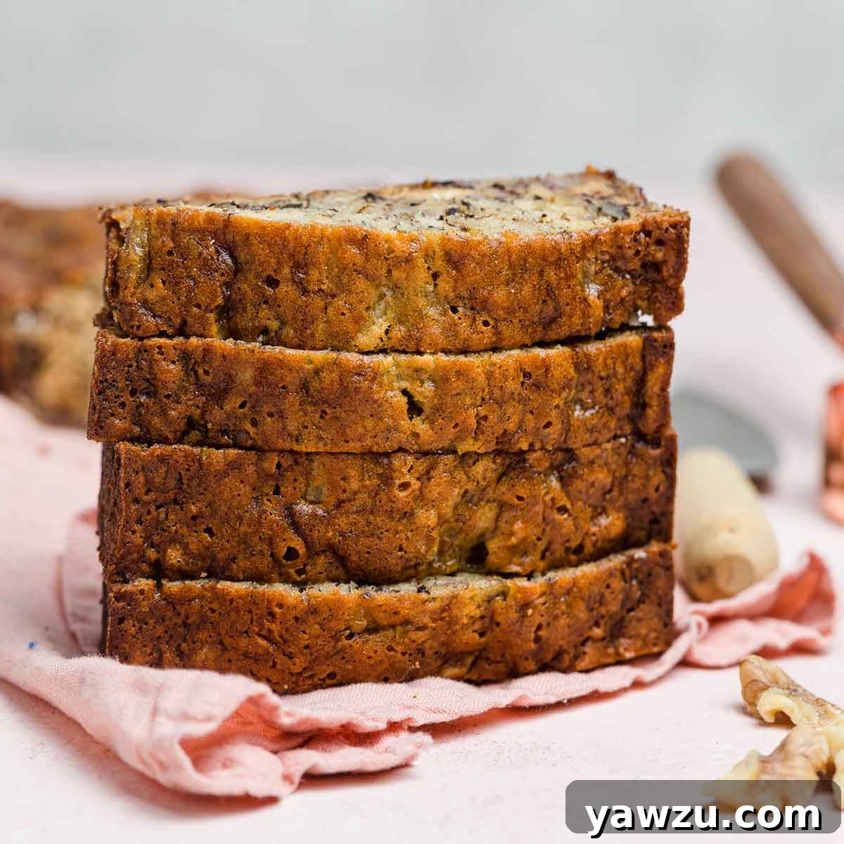 Front view of a perfectly baked stack of four moist and dense slices of Grandma's Banana Nut Bread.