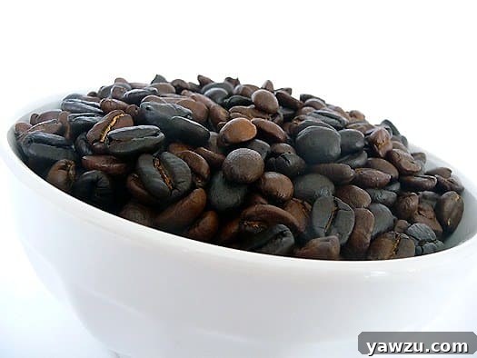Close-up of roasted espresso beans in a small white bowl, ready for brewing or infusion.