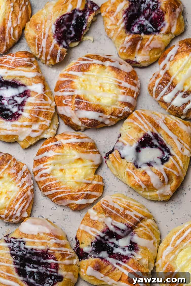 An inviting overhead photo of beautifully arranged cheese and fruit Danish pastries, perfectly baked and ready to be enjoyed.