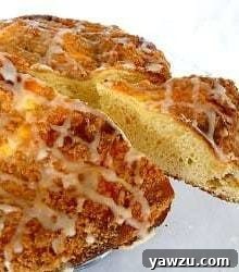 Coffee cake with icing on a glass serving platter with a slice removed.