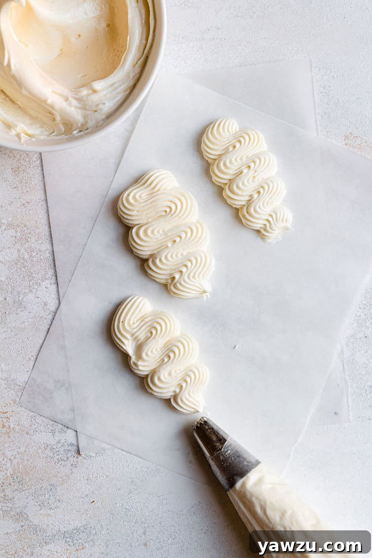 Cream Cheese Frosting expertly piped onto wax paper, showcasing its perfect texture, stability, and beautiful shape.