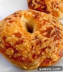 Asiago cheese bagel on a white plate.