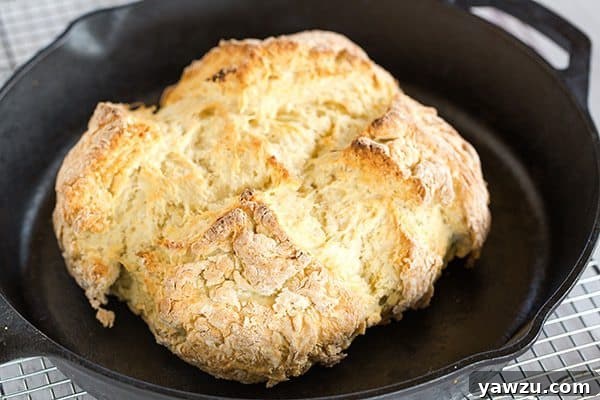A rustic loaf of Classic Irish Soda Bread, with a perfectly crisp crust and soft interior, ready to be sliced and enjoyed warm with butter.