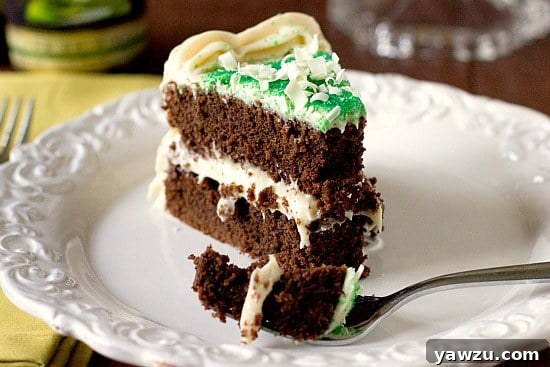 A luscious two-layer Guinness Chocolate Cake, generously frosted with creamy Baileys Irish Cream Cheese Frosting, ready to be sliced and enjoyed.
