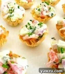 Cucumber tomato bruschetta bites in phyllo dough cups on a serving platter.