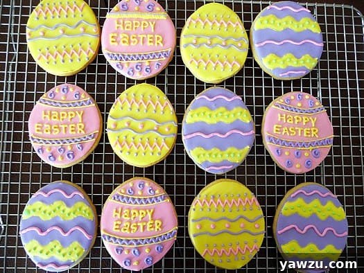 Sugar cookies decorated like Easter eggs on a cooling rack.