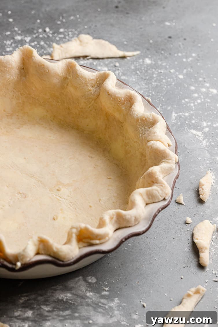 A dough-lined pie plate with fluted edges.