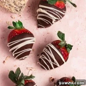 Chocolate covered strawberries elegantly drizzled with white chocolate, set against a chic pink counter, highlighting their festive and delicious appearance.