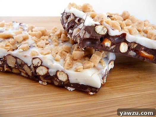 Two pieces of golden brown toffee pretzel bark on a rustic wood serving board, hinting at the perfect blend of sweet and salty.