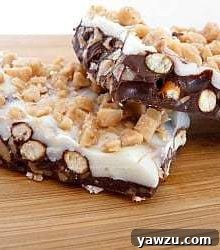 Two pieces of homemade Toffee Pretzel Bark artfully arranged on a rustic wooden platter.