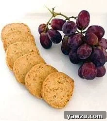 Parmesan and thyme crackers on a plate with grapes.
