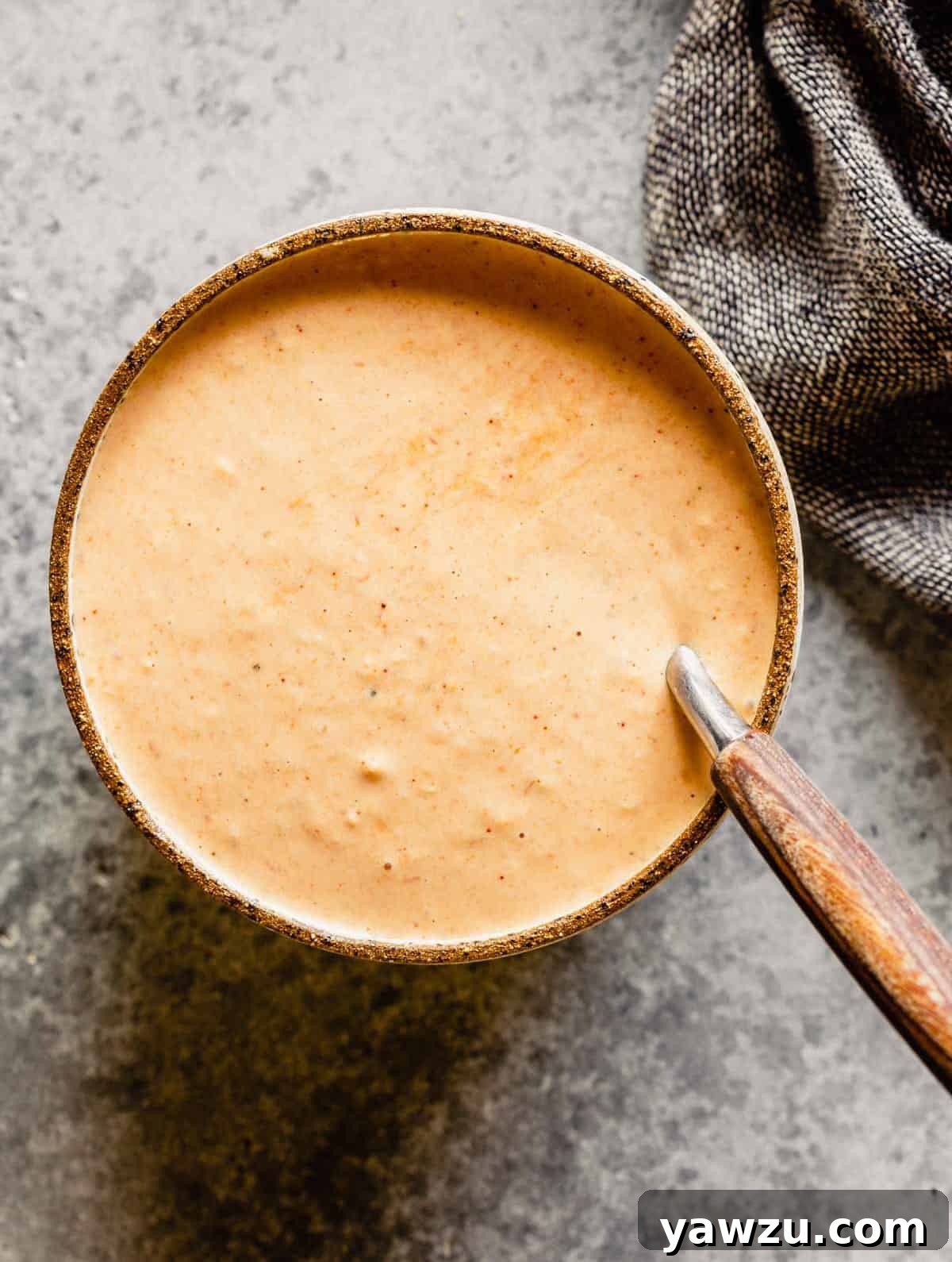 A bowl of Russian dressing that has been stirred with a spoon.