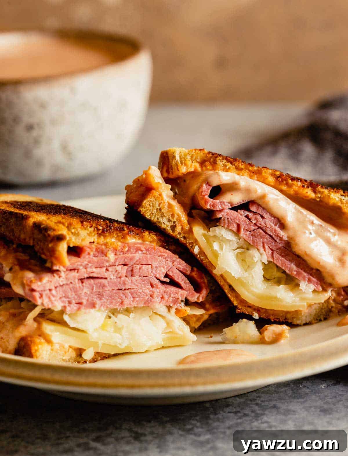 A Reuben sandwich cut in half on a plate.