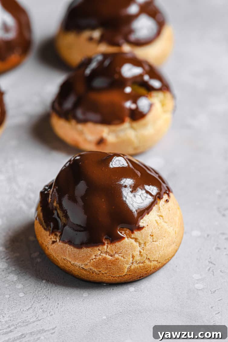 Chocolate dipped cream puffs on the counter.