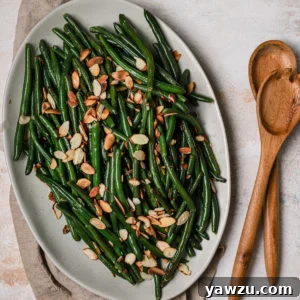 Green Beans Almondine in a serving bowl with wooden utensils