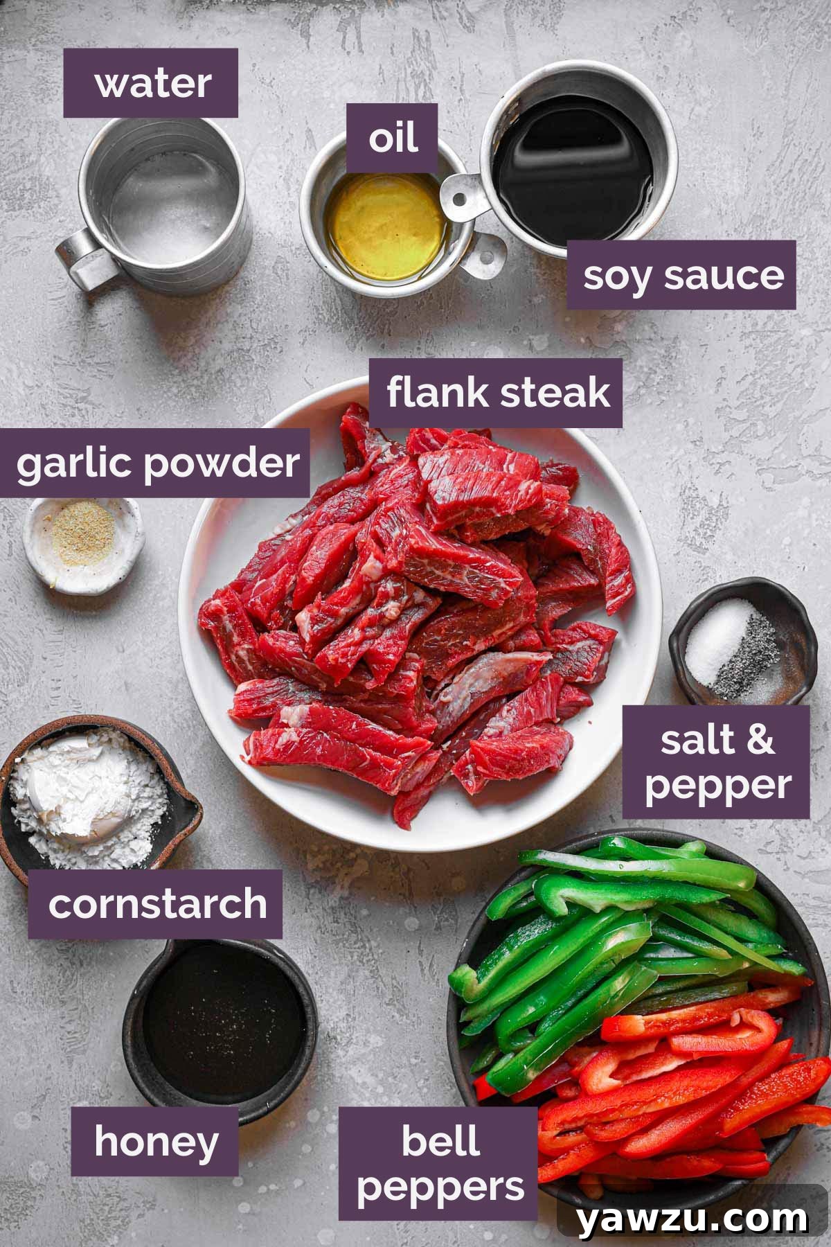 Fresh ingredients for steak and pepper stir fry, including sliced bell peppers, flank steak, soy sauce, and honey, neatly prepped and labeled on a cutting board.