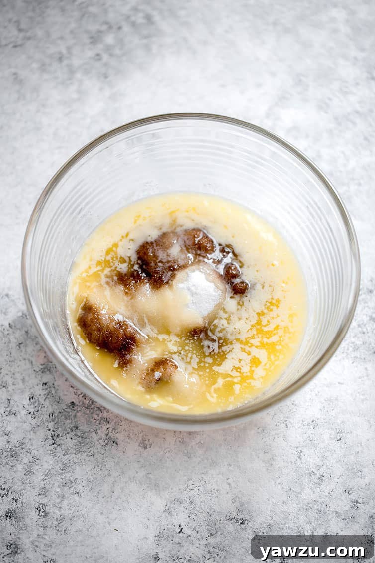 A mixing bowl filled with melted butter and rich brown sugar, ready to be combined.