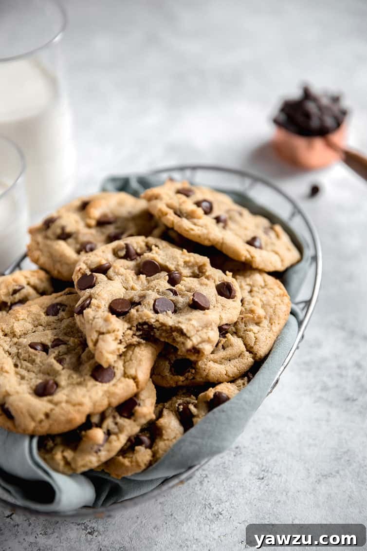 A charming basket filled with thick chocolate chip cookies, with one cookie showing a perfect bite taken out of it.