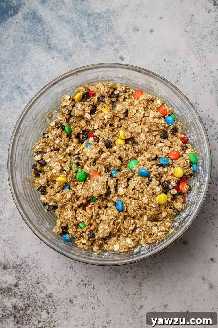 Monster cookie dough mixed together in glass bowl.
