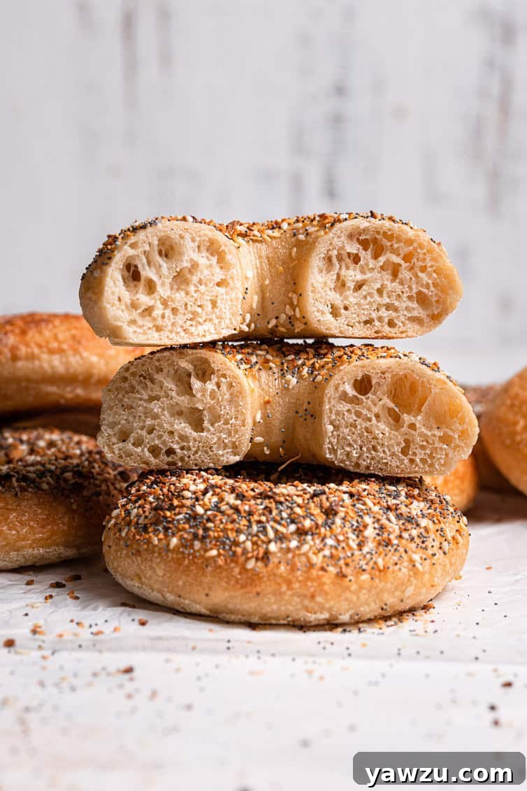 A bagel cut in half stacked on top of one another, showcasing its dense interior.