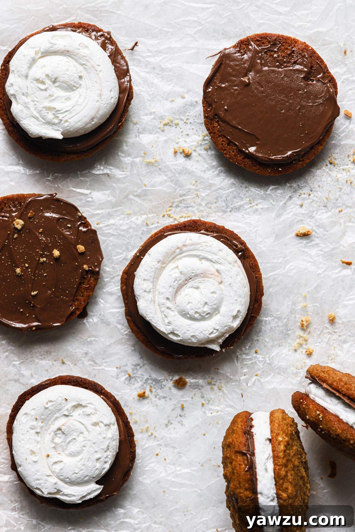 Step-by-step assembly of whoopie pies: chocolate ganache spread on one half, marshmallow cream layered on top, and finally topped with another cookie.