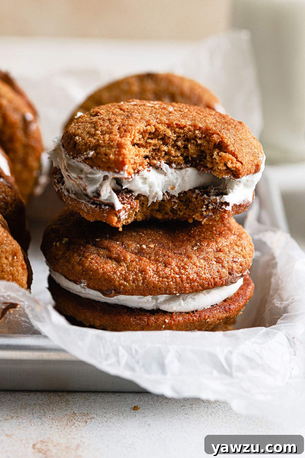 A close-up view of a S'mores whoopie pie with a large bite taken out, revealing the layers of filling.