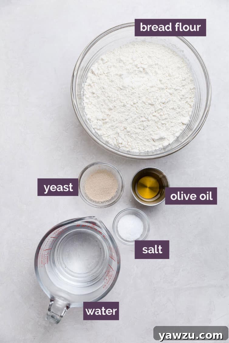 Assorted pizza crust ingredients, including a bowl of bread flour, instant yeast, salt, olive oil, and warm water, neatly arranged on a clean kitchen counter, ready for preparation.