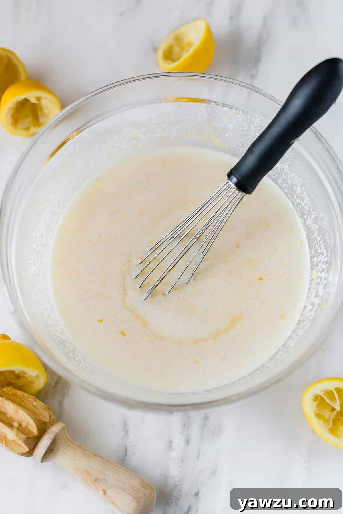 A bowl filled with the smooth, pale yellow lemon bar filling, perfectly mixed and ready to be poured into the crust. The consistency is visibly rich and creamy.