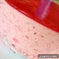 Side view of a beautifully presented strawberry mirror cake.