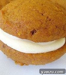 Pumpkin whoopie pie with maple cream cheese filling on a white plate.